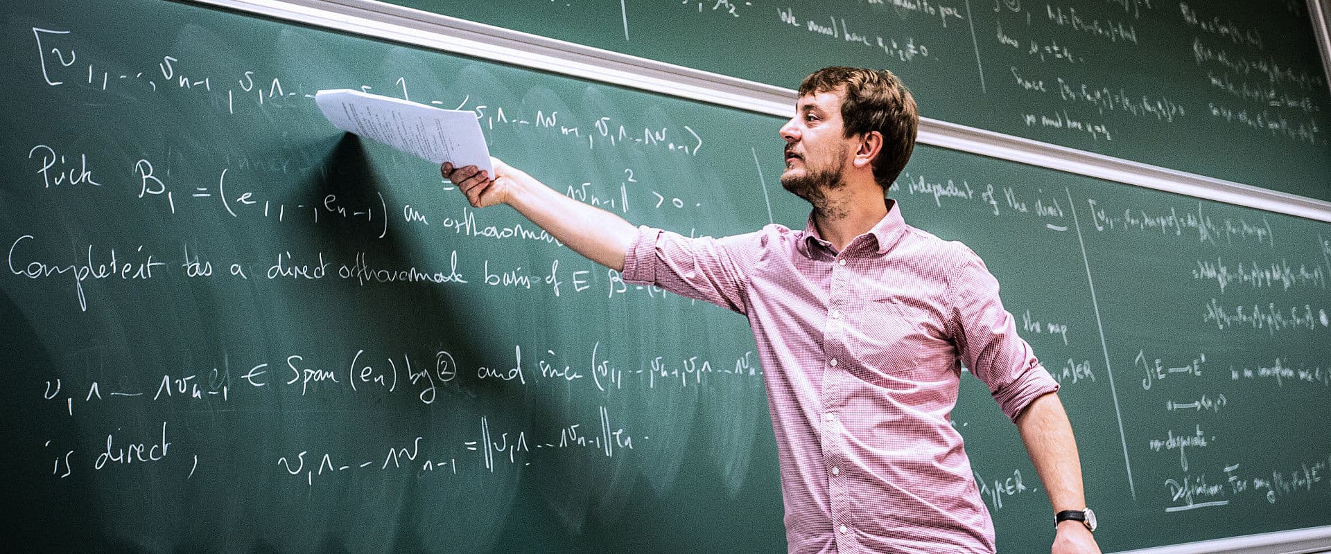 Lehrkraft erklärt Mathematik an der Tafel